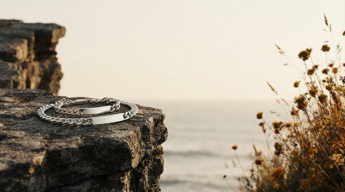 Two personalized Mobius strip bracelets resting on a coastal stone ledge during golden hour.